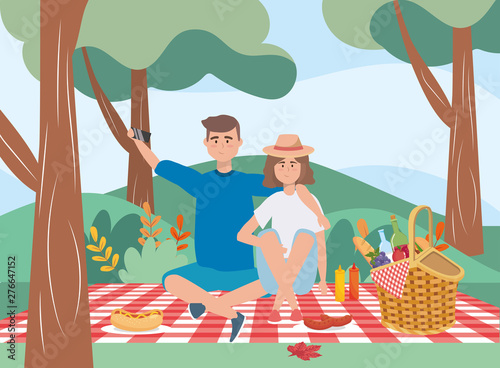 man and woman in the tablecloth with hamper and food