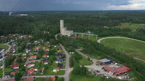 Drone footage flying over a residential area towards  a mining tower with a green pine forest in the background. Filmed in realtime at 4k. photo