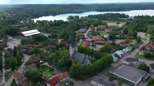 Drone footage flying over an old mining town towards a beautiful church and some old red houses with en small lake in the background. Filmed in realtime at 4k. photo