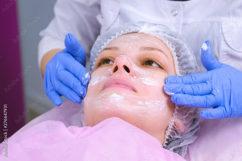 Beautician puts mask on woman's face. Cleaning face Beautician puts mask on woman's face. Cleaning face