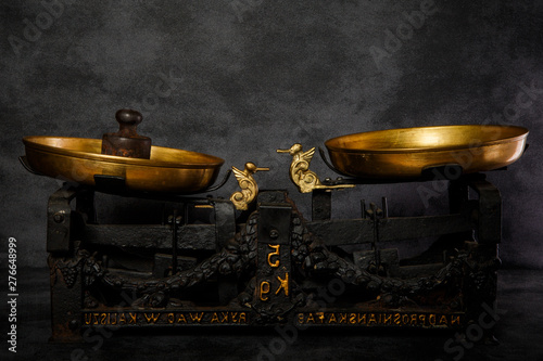 closeup antiquarian scales with two golden bowls and old weight