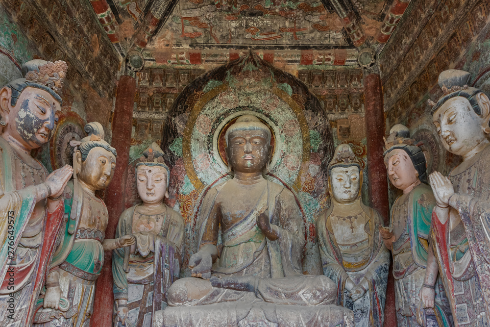 Color sculpture of Buddha and Bodhisattvas with colorful fresco in a niche within a grotto at Mount Maiji or Maijishan Grottoes, Tianshui, Gansu, China. Constructed from late fourth century CE.