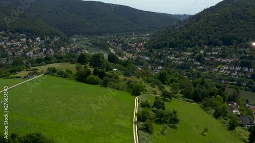 Aerial of Heidelberg-Ziegelhausen in Germany along the neckar river on  a sunny day in spring. Descending behind a hill. photo