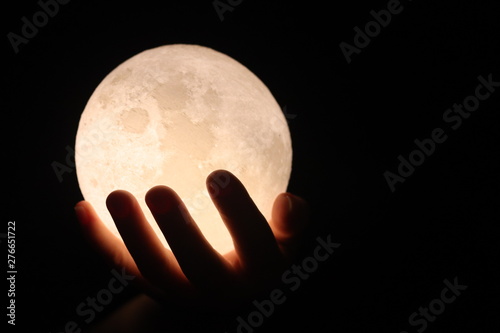 Full moon on hand and moon light with the black background.