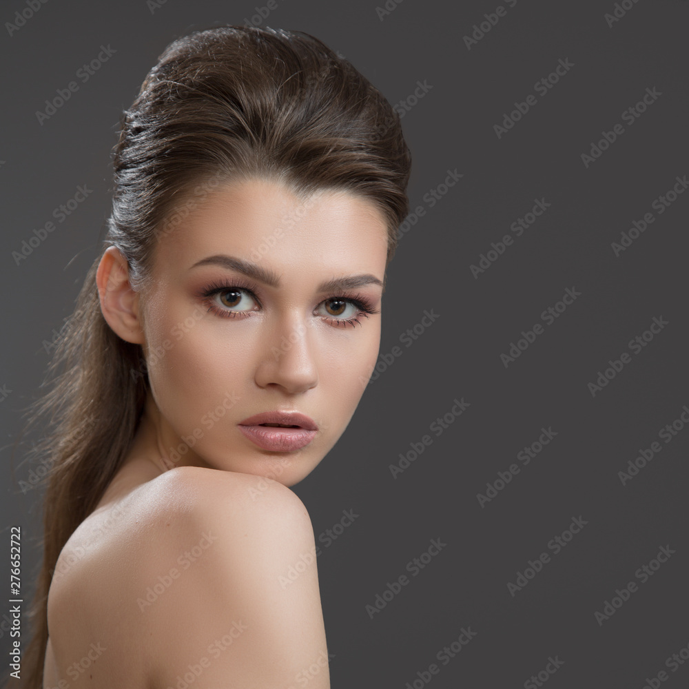 Beauty brunette woman with perfect makeup and skin. Beautiful professional holiday makeup, nude. Beauty girl face on dark background Beauty brunette woman with perfect makeup and skin. Beautiful professional holiday makeup, nude. Beauty girl face on dark background
