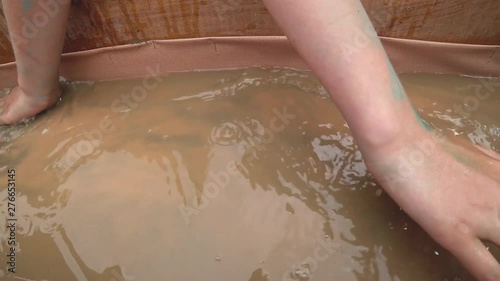 Search for gold in the gutter with running water with a high concentration of precious metal sand. Young hands carefully grope grains.