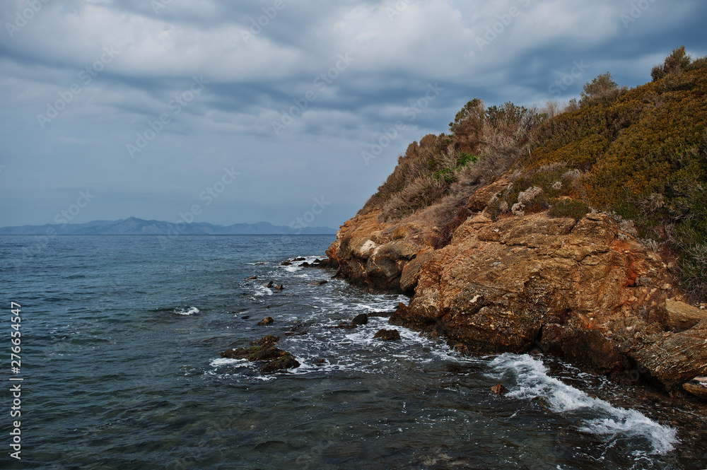 Sea wave breaks on beach rocks landscape. Sea waves crash and splash on rocks at Bodrum, Turkey.
