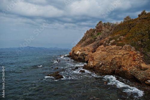 Sea wave breaks on beach rocks landscape. Sea waves crash and splash on rocks at Bodrum, Turkey.