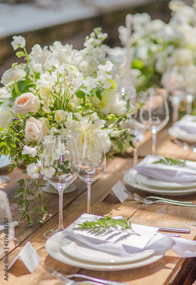 Fototapeta premium Close-up Decorative festive wooden table in vases flowers and candles for guests at a Wedding or a birthday party