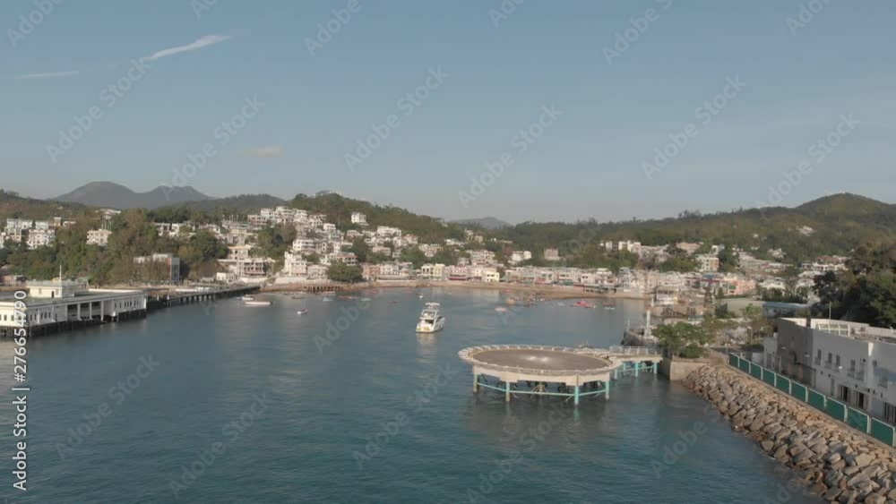 Aerial view of a helipad just outside of a coastal village located in a beautiful ocean bay. Aerial view of a helipad just outside of a coastal village located in a beautiful ocean bay.