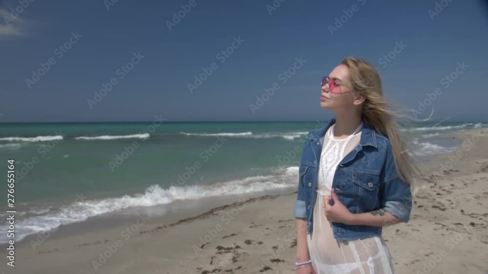 young sexy woman in white transparent dress with white hair flying in the wind enjoying the sun by the sea young sexy woman in white transparent dress with white hair flying in the wind enjoying the sun by the sea