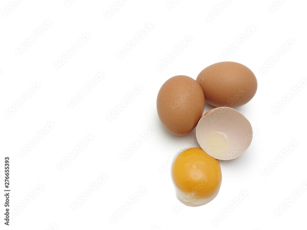 Whole eggs with cracked egg showing yolk isolated on white background Whole eggs with cracked egg showing yolk isolated on white background