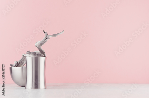 Trendy hi-tech decor for interior - elegant silver polished abstract decoration and old snag on white wood shelf and soft light pink background. photo