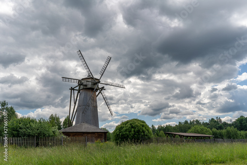 Old wooden windmill in a clearing near the forest.
