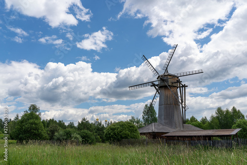 Old wooden windmill in a clearing near the forest.