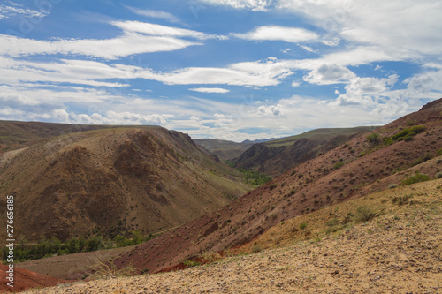 Red mountains in Kyzyl-Chin valley in Altay. Scenic landscape with clouds.