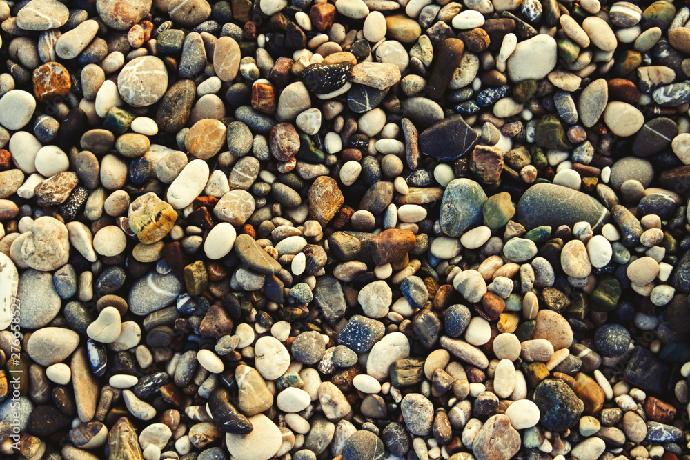 Beach stone pebbles. The texture of small stones and sand. Can be used as a texture, background or wallpaper