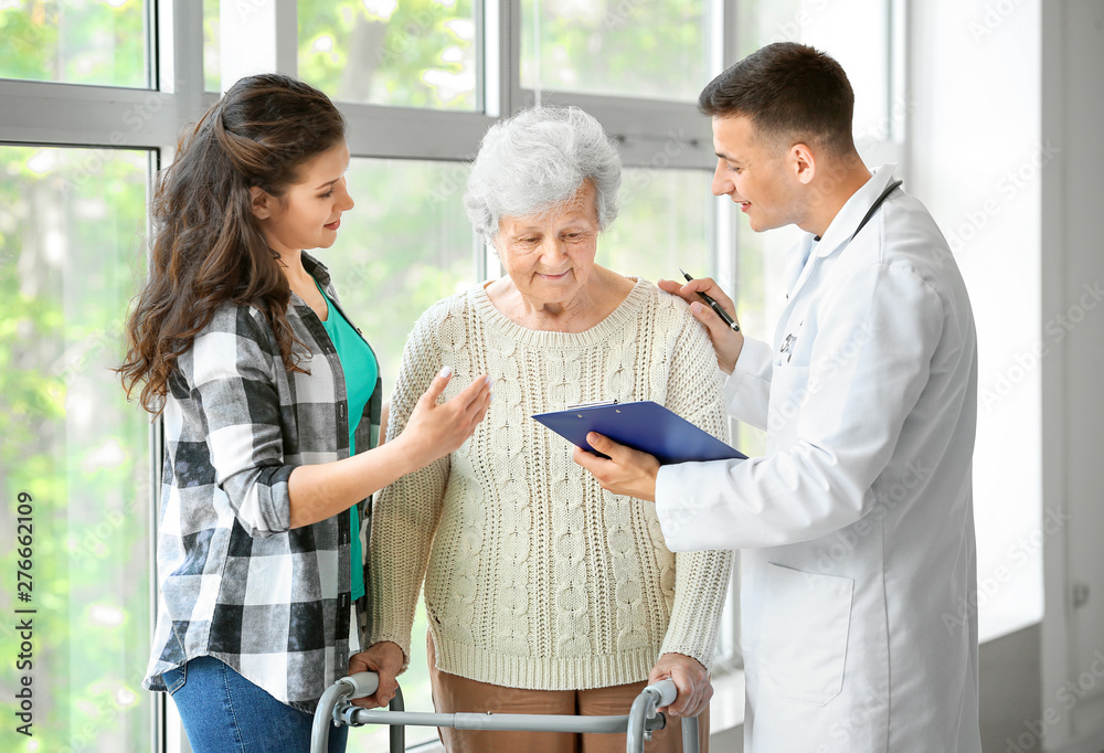 Fototapeta premium Senior woman with her granddaughter and doctor in hospital