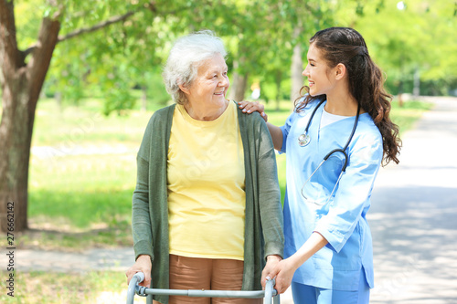 Caregiver walking with seni...
