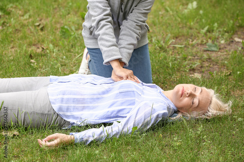 Female passer-by doing CPR ...