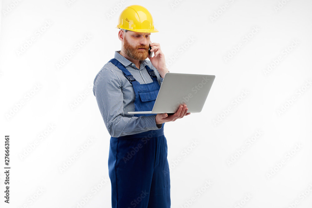 Engineer talking on the phone looking at the laptop Engineer talking on the phone looking at the laptop