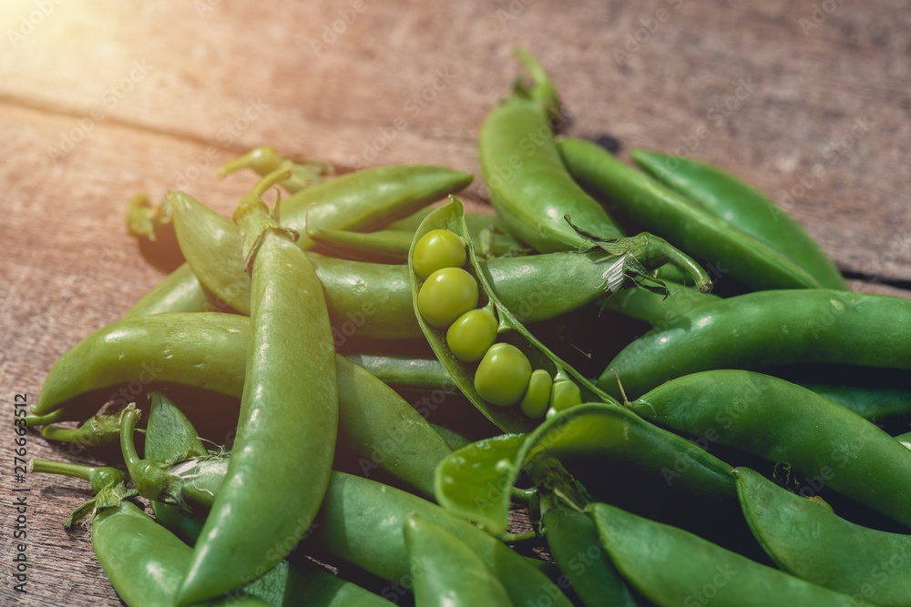 Fresh green peas or beans on wooden table