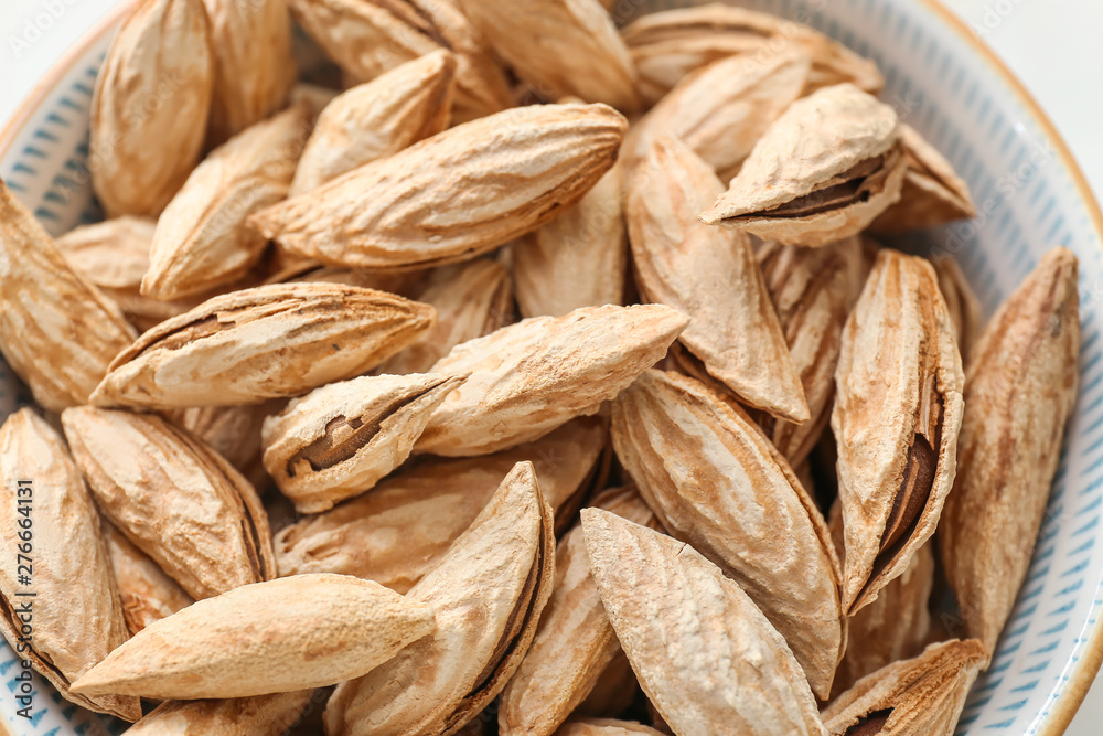 Bowl with unpeeled almond nuts, closeup Bowl with unpeeled almond nuts, closeup