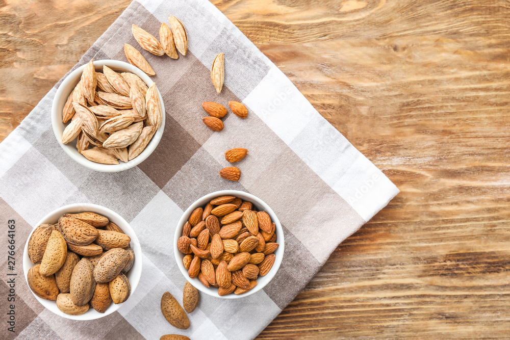 Bowls with almonds on wooden table Bowls with almonds on wooden table