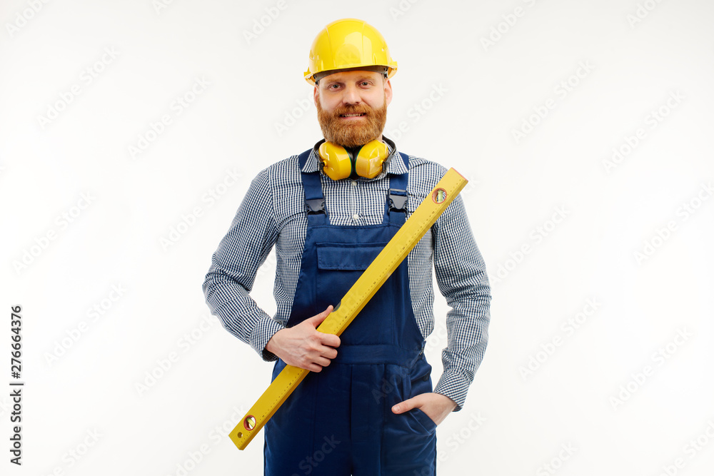 Engineer stands with a leveling ruler in his hands on a white background Engineer stands with a leveling ruler in his hands on a white background