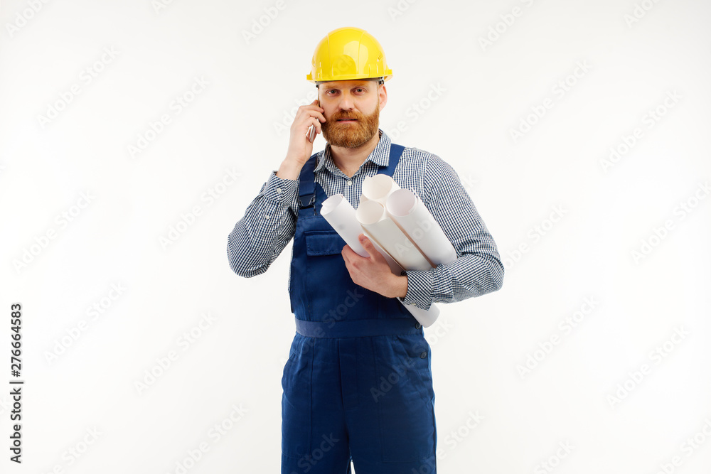 Engineer talking on the phone with a drawing in his hand on a white background Engineer talking on the phone with a drawing in his hand on a white background