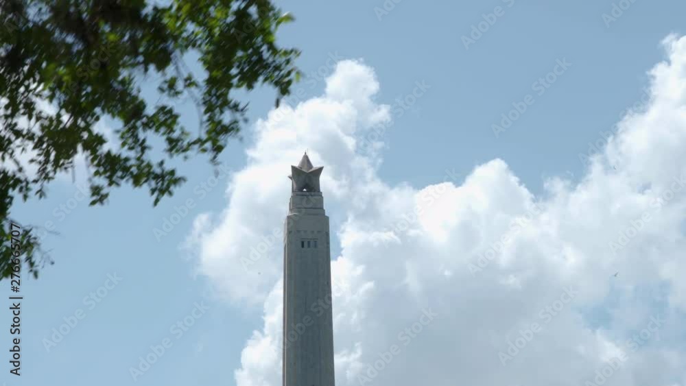 View of the top of the San Jacinto Monument through the trees in Houston, Texas