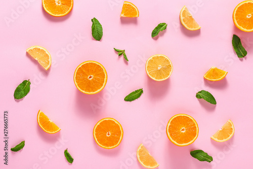 Sliced citrus fruits and mint leaves on color background