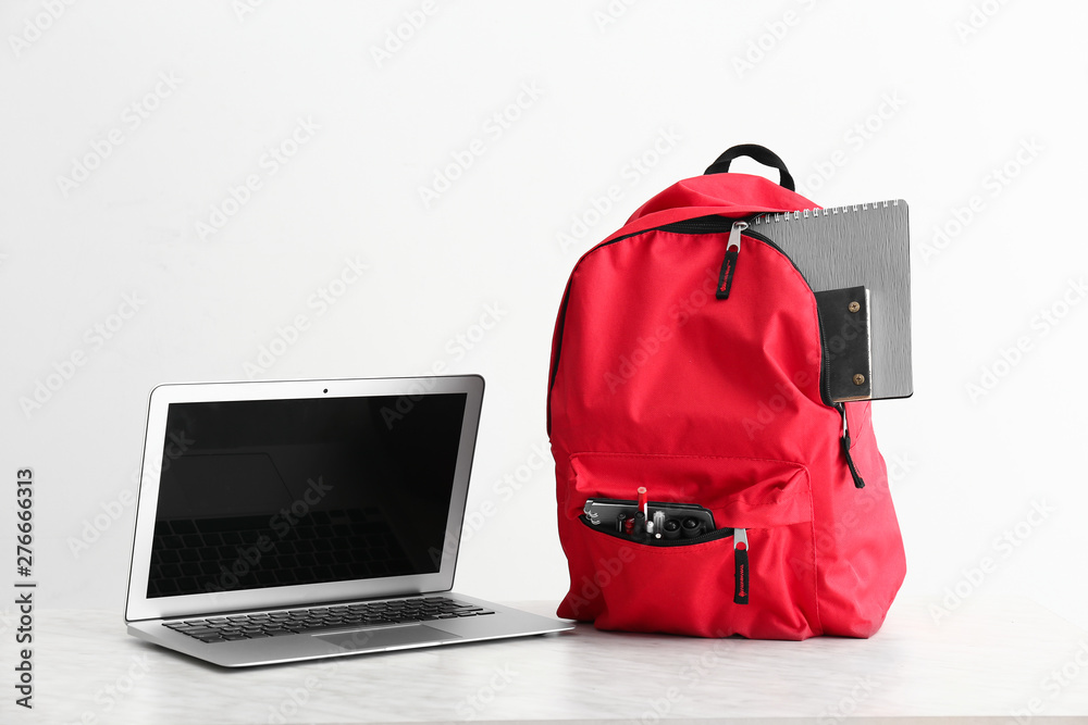 School backpack and laptop on white background - obrazy, fototapety, plakaty 