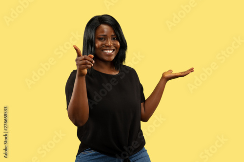 Konstfotografi Young african-american woman isolated on yellow studio background, facial expression