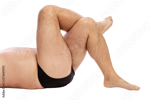 Men's hairy crossed legs. Excess weight. Close-up. Isolated on a white background. photo