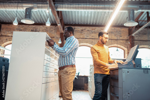 Two men working in light spacious printing office