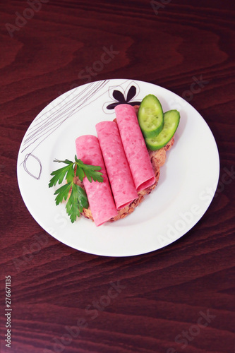 sandwich of rye bread with meat sausage, cucumbers and parsley