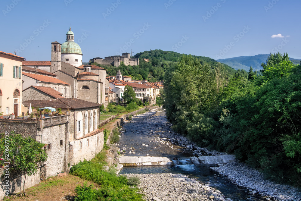 Tuscan village of Pontremoli with the Magra river in the forefront and iconic buildings in the background.