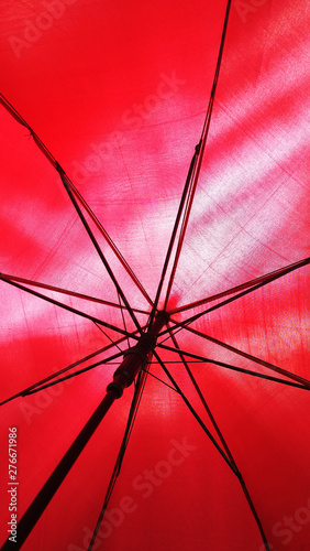 close up of under a red umbrella of its metal frames