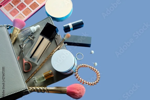 Makeup products with cosmetic bag and macaroons on light background