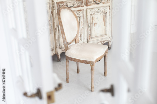 Vintage chair with textile upholstery in a luxurious interior. Soft focus.