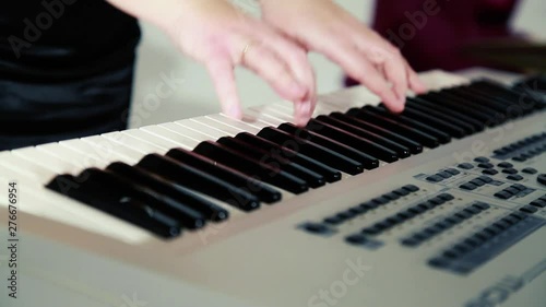 hands of a woman in a black dress playing a synthesizer with a lot of turning buttons jazzy