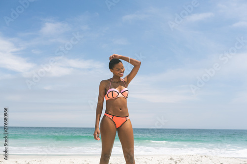Woman posing while standing on beach  © wavebreak3