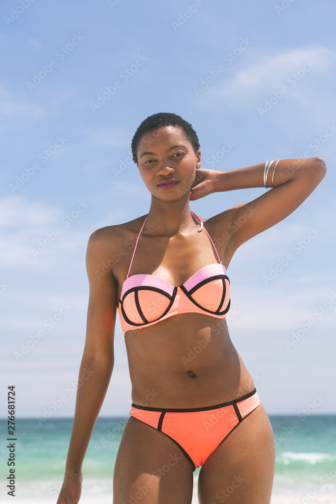 Woman posing while standing on beach on a sunny day Woman posing while standing on beach on a sunny day
