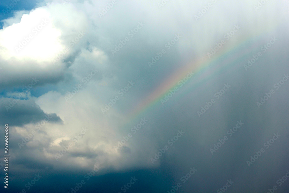 blue sky, rainbow in the clouds