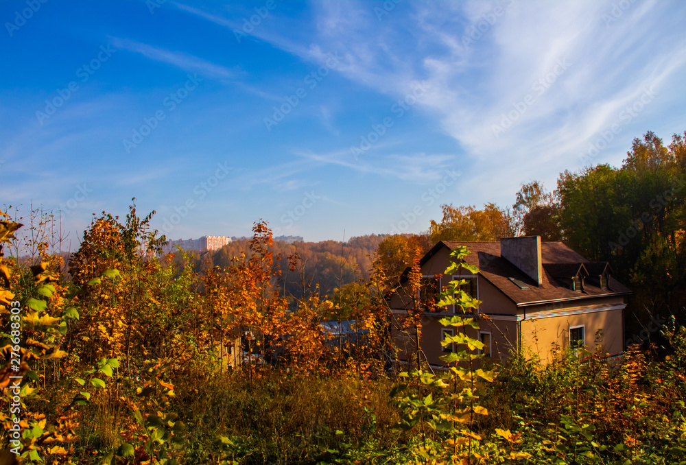 A cozy house is elegantly located among the golden trees A cozy house is elegantly located among the golden trees