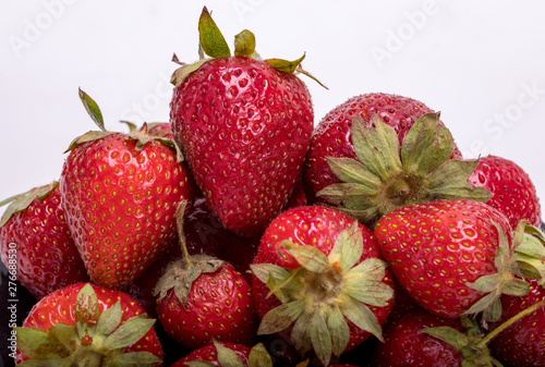 fresh ripe strawberries on black plate isolated on white background