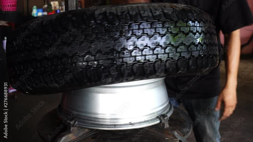 Car service mechanic change tire using wheel balancing mounting tool machine. Car service mechanic change tire using wheel balancing mounting tool machine.