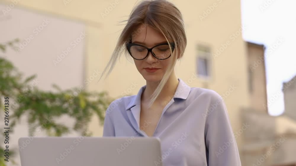 Cute lady working at desk in the old town. Pretty face close up with emotion of joy and happy success. Student writing a report on successful marketing