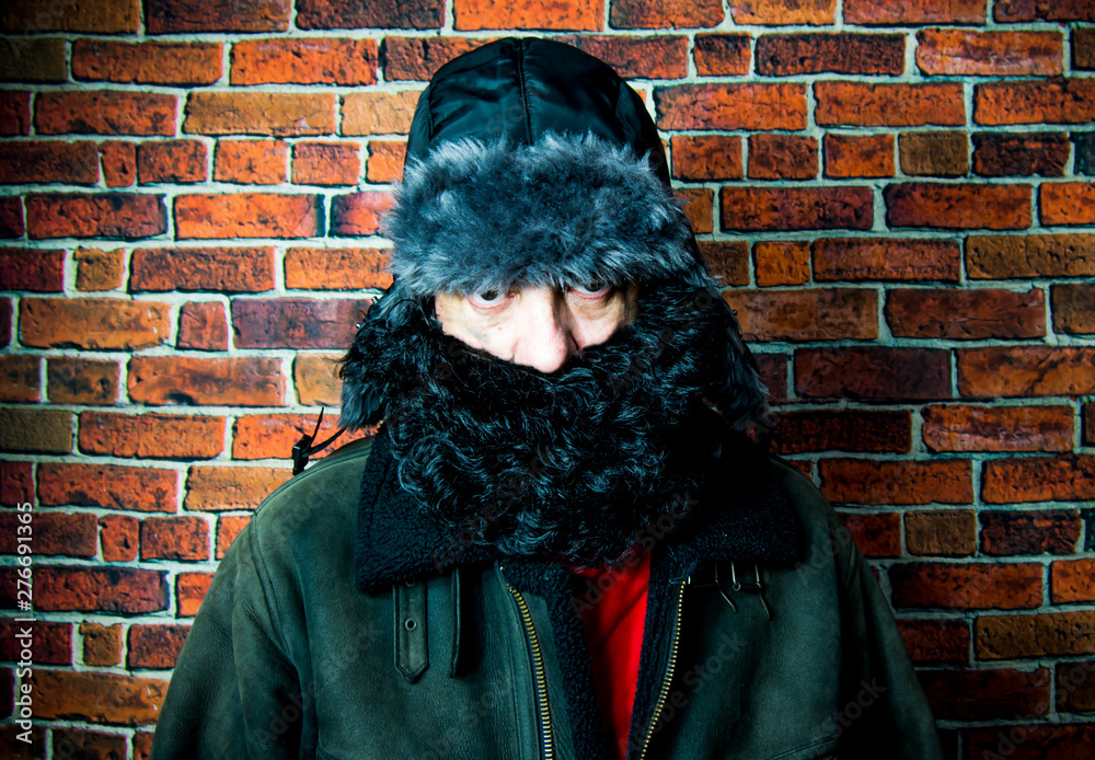 Naklejka premium Steampunk man with beard, hat and glasses on background of vintage brick wall
